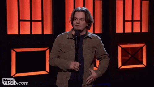 Man Standing In Front Of Microphone With TBS Logo GIF