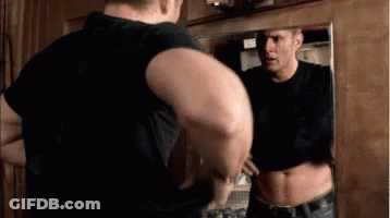 Man Standing In Front Of Mirror Looking At Himself GIF