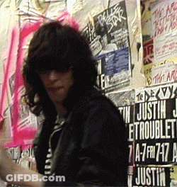 Man Standing In Front Of Posters GIF