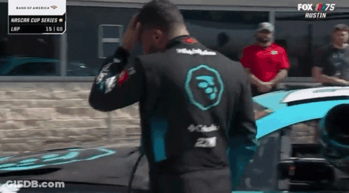 Man Standing In Front Of Race Car With Fox 75 Logo GIF