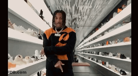 Man Standing In Front Of Shelf Full Of Shoes GIF