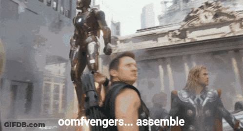 Man Standing In Front Of Statue Saying Assemble GIF