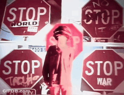Man Standing In Front Of Stop Signs GIF