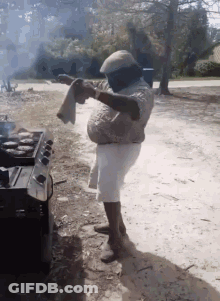 Man Standing In Front Of Stove Holding Towel GIF
