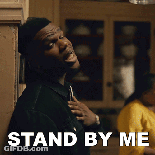 Man Standing In Front Of Wall Saying Stand By Me GIF