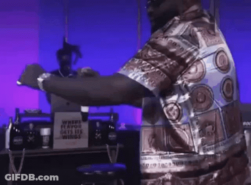 Man Standing In Front Of Where Flavor Gets His Wings Sign GIF