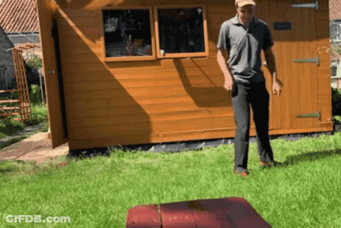 Man Standing In Front Of Wooden Shed GIF