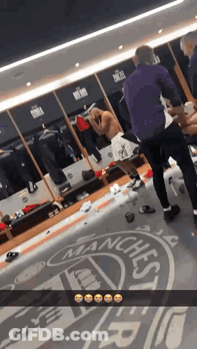 Man Standing In Locker Room With Manchester Logo GIF