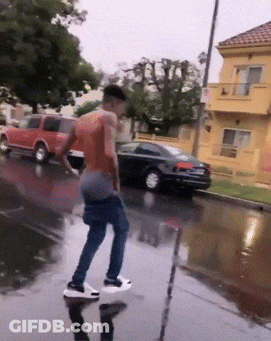 Man Standing In Puddle On Wet Street GIF
