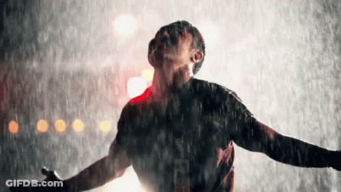 Man Standing In Rain Arms Outstretched Looking Up GIF