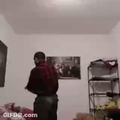 Man Standing In Room With Painting And Shelf GIF