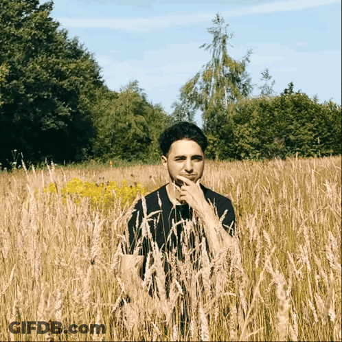 Man Standing In Tall Grass GIF
