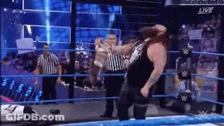 Man Standing In Wrestling Ring With Referee GIF