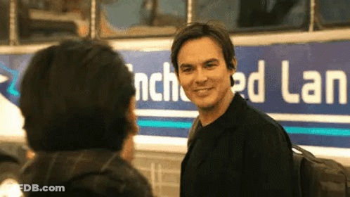 Man Standing Next To Another Man In Front Of Bus GIF