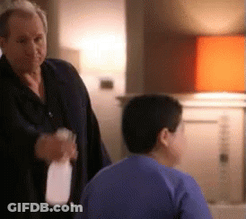 Man Standing Next To Boy In Blue Shirt Holding Milk GIF