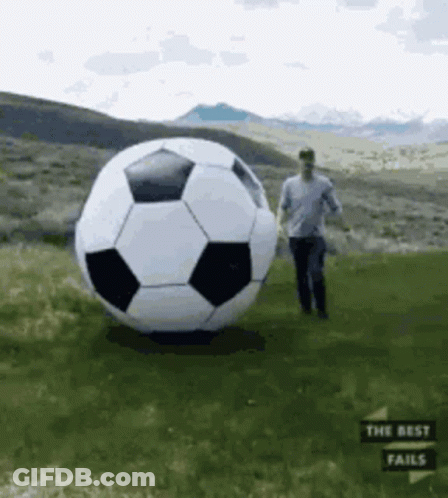 Man Standing Next To Large Soccer Ball GIF