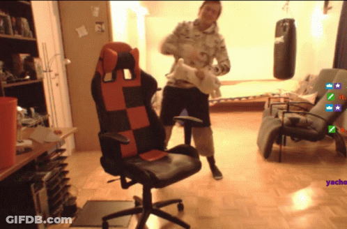 Man Standing Next To Red And Black Chair GIF