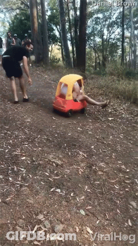 Man Standing Next To Red Toy Car With Yellow Top GIF