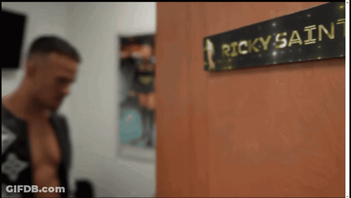 Man Standing Next To Ricky Sainz Sign GIF