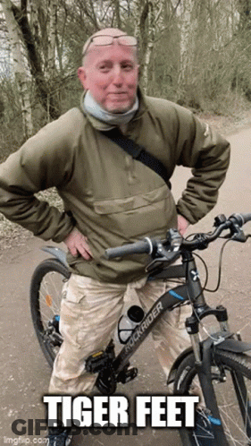 Man Standing Next To Rockrider Bike Saying Tiger Feet GIF