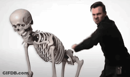 Man Standing Next To Skeleton With Skull GIF