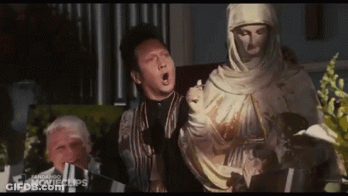Man Standing Next To Veiled Woman Statue GIF