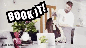 Man Standing Next To Woman At Table With Laptop And Flowers GIF