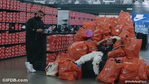 Man Standing Next To Woman On Nike Bags GIF
