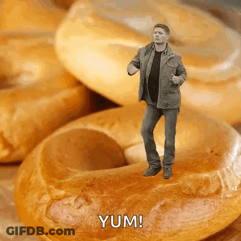 Man Standing On Bagel Saying Yum GIF