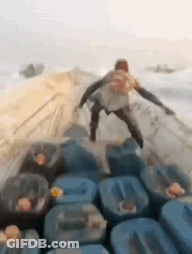 Man Standing On Blue Barrels GIF
