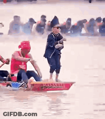Man Standing On Boat As People Row GIF