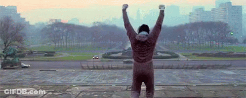 Man Standing On Ledge With Arms Up GIF