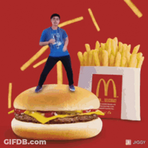 Man Standing On McDonald's Hamburger Next To Fries GIF