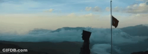 Man Standing On Mountain With Flag GIF