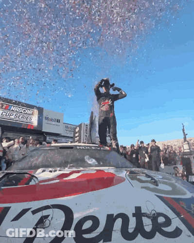 Man Standing On NASCAR Car With Confetti GIF