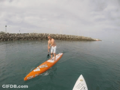 Man Standing On Surfboard SST GIF