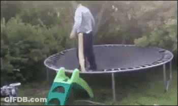Man Standing On Trampoline Next To Green Slide GIF