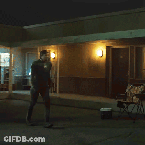 Man Standing Outside Building With Wall Light GIF
