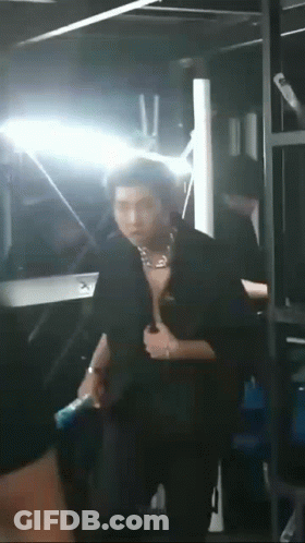 Man Standing Shirtless In Front Of Mirror In Dark Room GIF