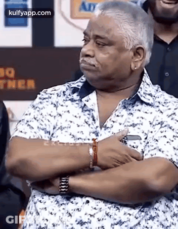 Man Standing With Arms Crossed In Front Of Crowd GIF