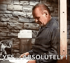 Man Standing With Paper In Front Of Brick Wall GIF