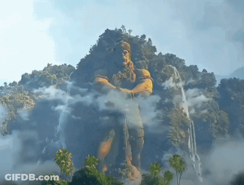 Man Statue On Mountain With Trees And Clouds GIF