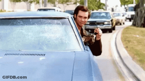 Man Sticking Head Out Of Blue Car Holding Remote GIF