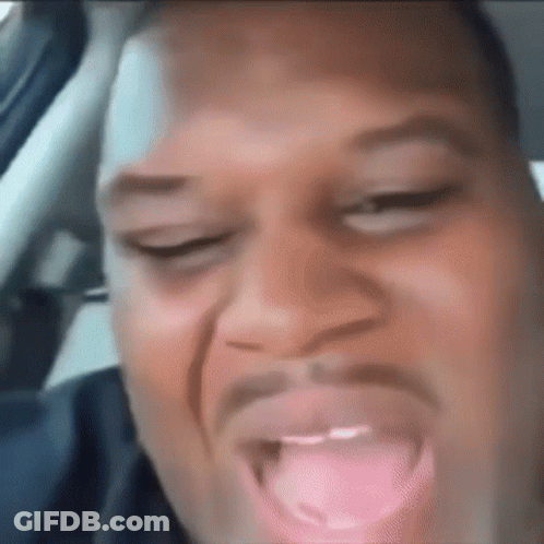 Man Sticking Tongue Out In Car Making Funny Face GIF