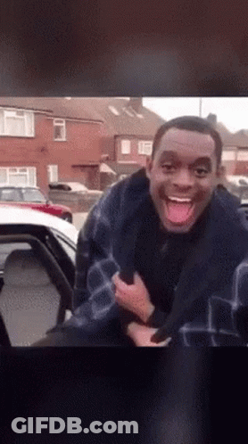 Man Sticking Tongue Out Next To Car GIF