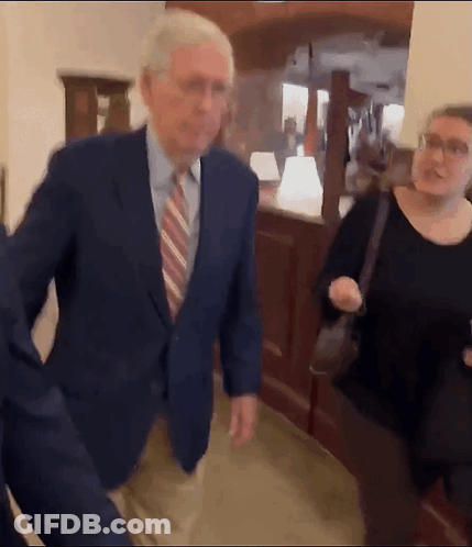 Man Suit Tie Walking Hallway Woman Behind GIF