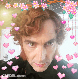 Man Surrounded By Hearts And Flowers GIF
