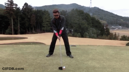 Man Swinging At Ball On Golf Course GIF