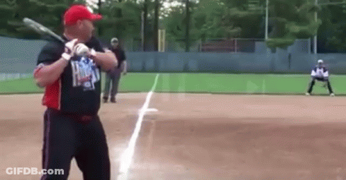 Man Swinging Bat On Baseball Field GIF