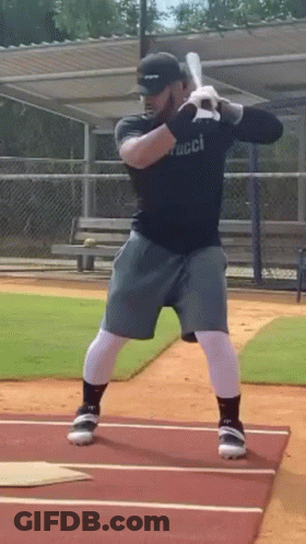 Man Swinging Bat On Baseball Field GIF